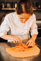 Female chef is making dessert with apricots and crepe - CAVF82708