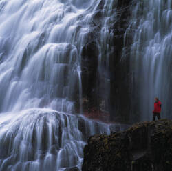 Woman admiring Dynjandi waterfall in the remote fjords of Iceland - CAVF82755