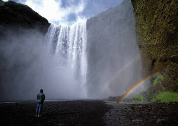 Mann vor dem Wasserfall Skogarfoss in Island - CAVF82756