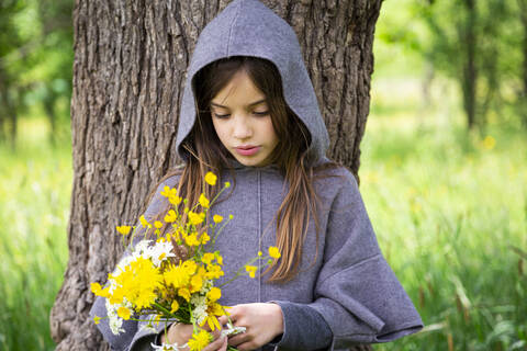 Girl picking yellow wildflowers stock photo