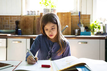 Mädchen macht Hausaufgaben in der Küche zu Hause - LVF08915