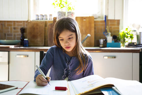 Girl doing homework in kitchen at home - LVF08915