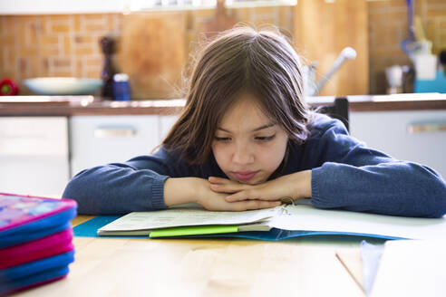 Girl doing homework in kitchen at home - LVF08917