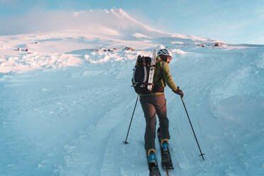 Mann beim Skifahren in Richtung Mt Hood bei Sonnenaufgang im Winter - CAVF82838