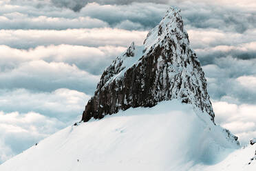 Illumination rock on Mt Hood with snowboarder riding below at sunset - CAVF82843