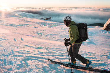 Snowboarder touring in backcountry during sunrise on Mount Hood - CAVF82845
