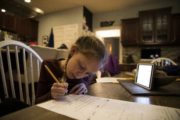 Close-in View of Young Girl At Kitchen Table Doing School Work - CAVF82884