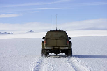 Maßgeschneiderter SUV pflügt durch verschneite Landschaft auf isländischem Gletscher - CAVF82964