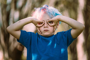 Young boy making upside down hand glasses - CAVF82998