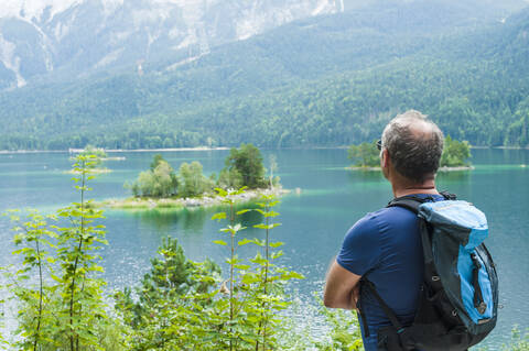 Senior man enjoying view over Eibsee stock photo