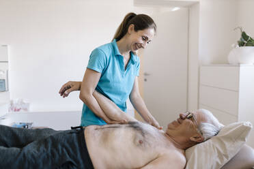 Female physiotherapist giving treatment to senior patient - DAWF01549