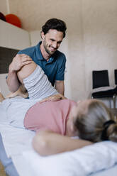 Physiotherapist giving treatment to female patient - DAWF01559