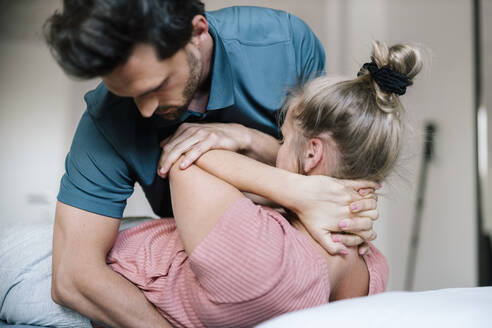 Physiotherapist giving treatment to female patient - DAWF01565