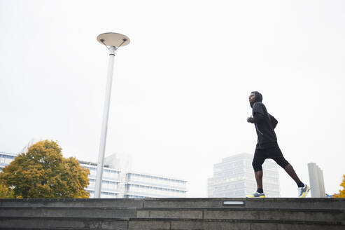 Junger Mann beim Joggen in der Stadt - DIGF12234