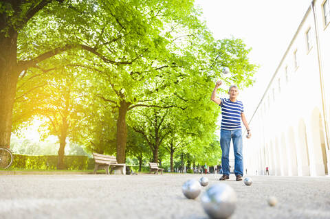 Senior man throwing boules ball stock photo