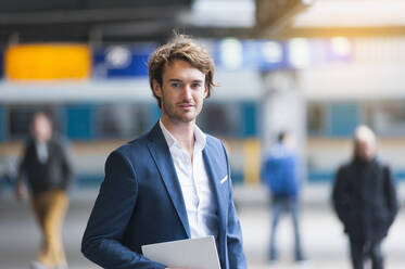 Porträt eines jungen Geschäftsmannes mit digitalem Tablet am Bahnhof - DIGF12297