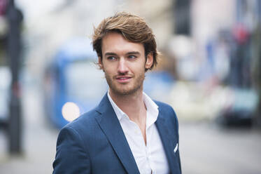 Portrait of young businessman with stubble outdoors - DIGF12303