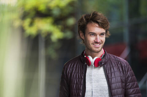Porträt eines lächelnden jungen Mannes mit Kopfhörern, lizenzfreies Stockfoto