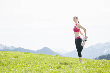 Joggerin streckt ihr Bein, Wallberg, Bayern, Deutschland - DIGF12350