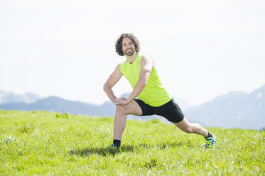 Jogger streckt sein Bein aus, Wallberg, Bayern, Deutschland - DIGF12352