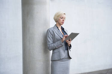 Porträt einer blonden Geschäftsfrau mit Tablet - DIGF12366