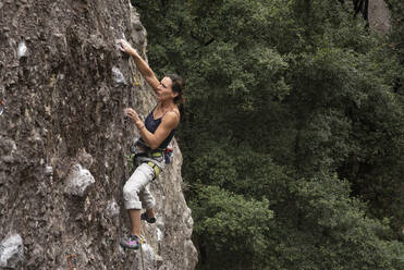 Eine Frau hält sich beim Klettern in Jilotepec konzentriert fest - CAVF83041