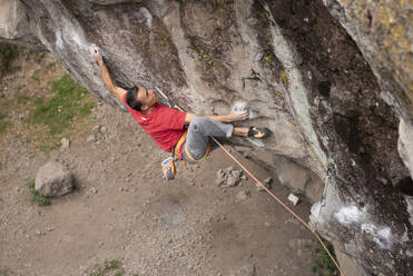 One man wearing red hold himself while rock climbing in Jilotepec - CAVF83042