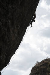 Silhouette eines Mannes beim Klettern an einer überhängenden Wand in Jilotepec - CAVF83049