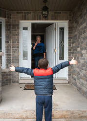 Besuch aus sozialer Distanz zwischen einem kleinen Jungen und seiner Großmutter zu Hause. - CAVF83076