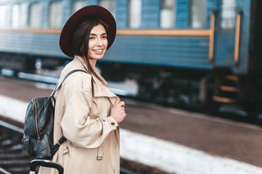 Porträt einer jungen schönen Frau, die auf einen Zug wartet - CAVF83138