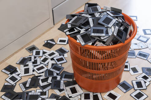 Germany, Wastepaper basket overfilled with bar-coded photographic slides - SIEF09863