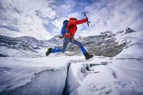 Bergsteiger beim Sprung über eine Gletscherspalte, Großvendigergletscher, Tirol, Österreich - PNEF02606