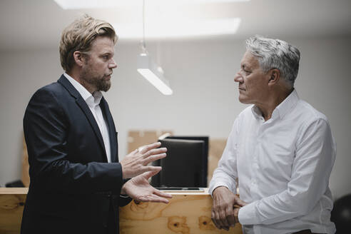 Geschäftspartner stehen im Büro und unterhalten sich - GUSF03821