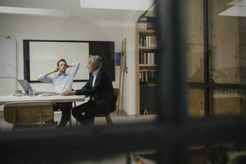 Unternehmer, die sich in einem modernen Büro treffen und über Geschäfte sprechen - GUSF03936