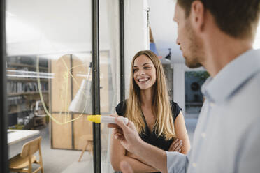 Young businesswoman discussing with colleague in office at a meeting - GUSF03943