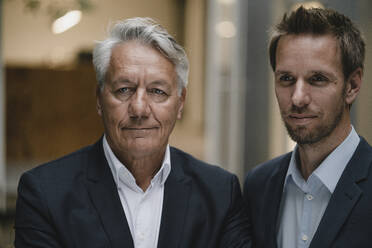 Portrait of two businessmen, looking at distance - GUSF03976