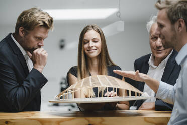 Erfolgreiche Geschäftsleute betrachten das architektonische Modell im Büro - GUSF04001