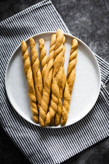 Teller mit frischen italienischen Grissini-Brotstangen - GIOF08240