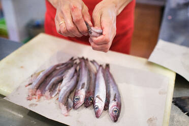 Die Hand einer jungen Frau bringt ihren Kunden im Fischgeschäft Garnelen bei - CAVF83265