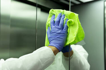 Coronavirus. Worker disinfecting hospital elevator to avoid contagion. - CAVF83286