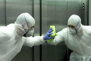 Coronavirus. Worker disinfecting hospital elevator to avoid contagion. - CAVF83288