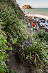 Vater und Kinder beim Wandern am Meer in Neuseeland - CAVF83290