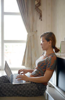 Frau benutzt Computer-Laptop für Arbeit von zu Hause aus - CAVF83316