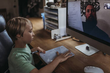 Close up view of young student taking online class during isolation - CAVF83468