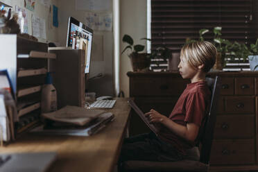 School aged boy learning online by video chat during homeschool - CAVF83471