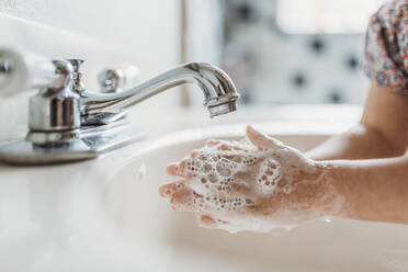 Nahaufnahme eines kleinen Kindes beim Händewaschen mit Seife im Waschbecken - CAVF83494