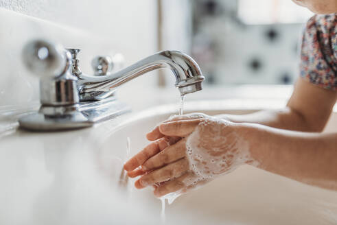 Nahaufnahme eines kleinen Kindes beim Händewaschen mit Seife im Waschbecken - CAVF83496