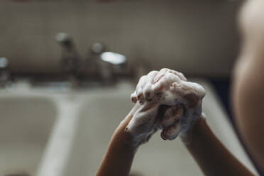 Close up of young hands being washed with soap - CAVF83504