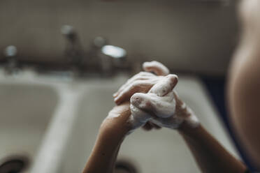 Close up of young hands being washed with soap - CAVF83506