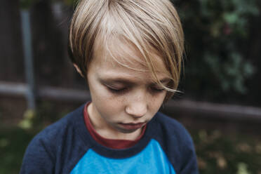 Close up of young boy with eyes closed and freckles - CAVF83514